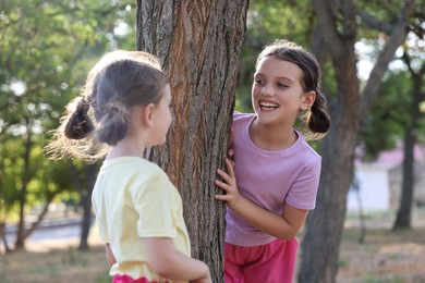 Cute little sisters spending time together in park