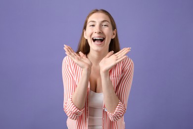 Photo of Smiling girl with braces on purple background