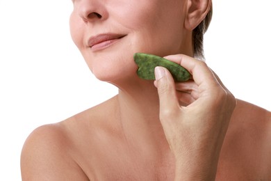 Woman doing facial massage with gua sha tool on white background, closeup