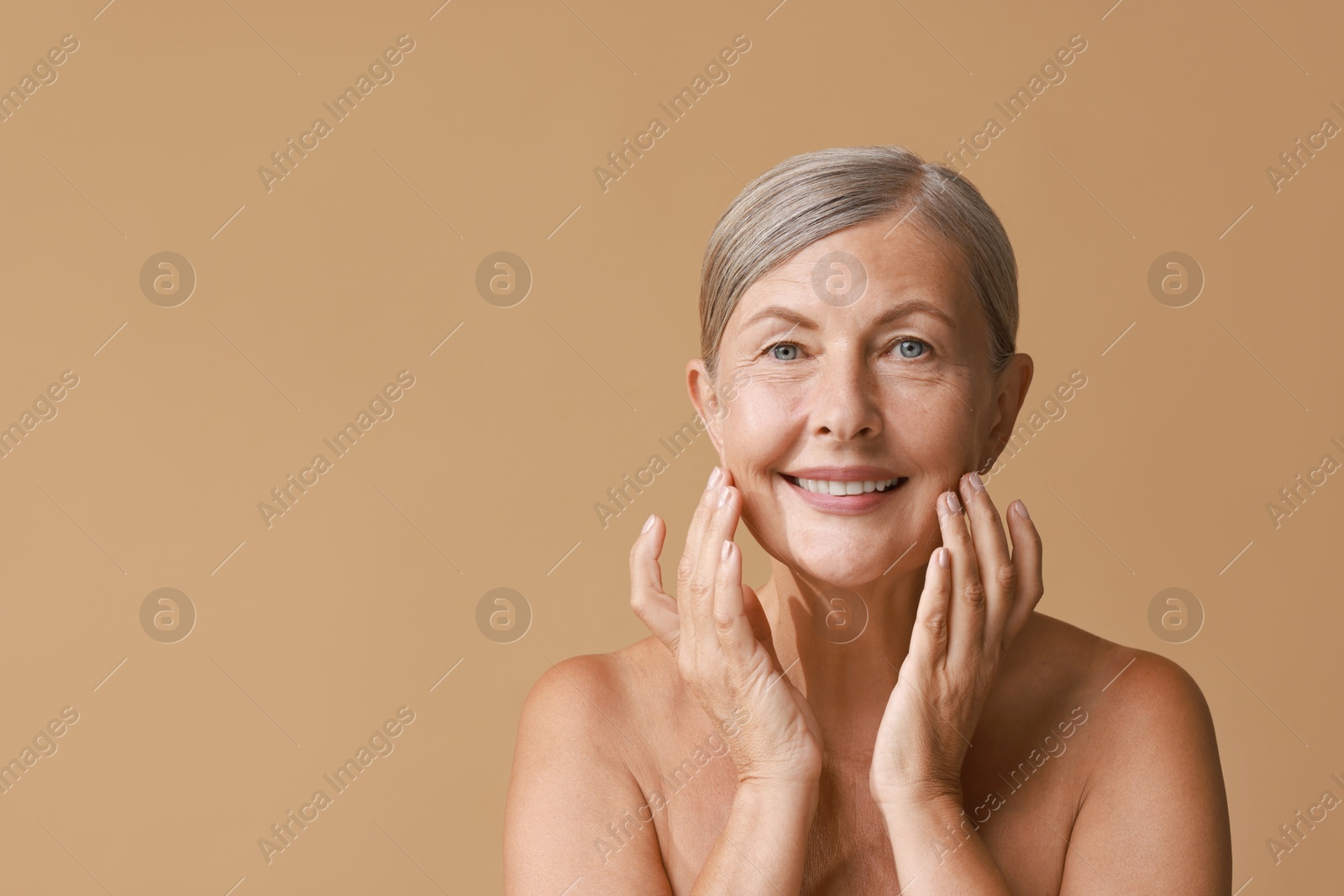 Photo of Face massage. Beautiful woman with healthy skin on beige background, space for text