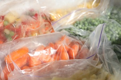 Photo of Plastic bags with different frozen vegetables in refrigerator, closeup