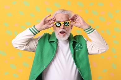 Excited man with sunglasses on yellow background. Percent signs on lenses. Discount, hot offer