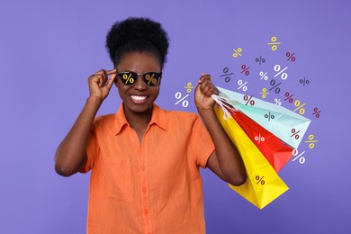 Image of Woman with sunglasses and shopping bags on violet blue background. Percent signs on lenses. Discount, hot offer