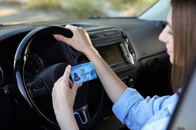 Driving school. Woman with driving license in car, selective focus