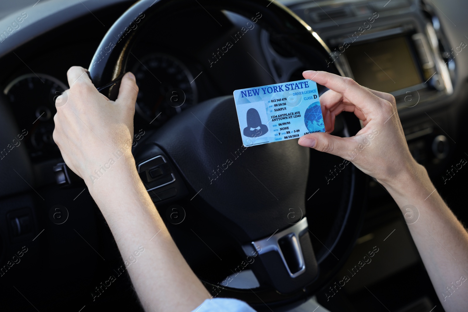 Photo of Driving school. Woman with driving license in car, closeup