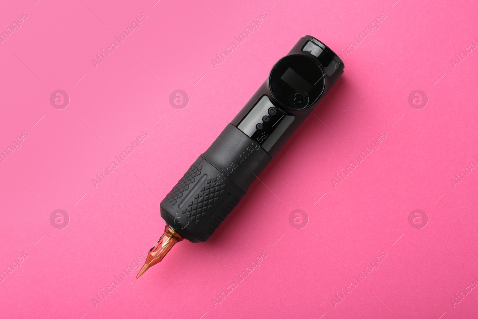 Photo of Professional permanent makeup machine with power supply on pink background, top view