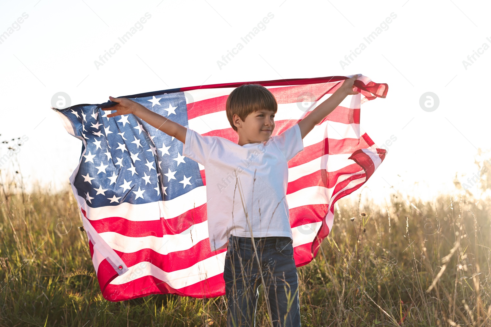 Photo of Little boy with flag of USA outdoors