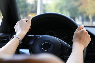 Photo of Woman holding steering wheel while driving car, closeup