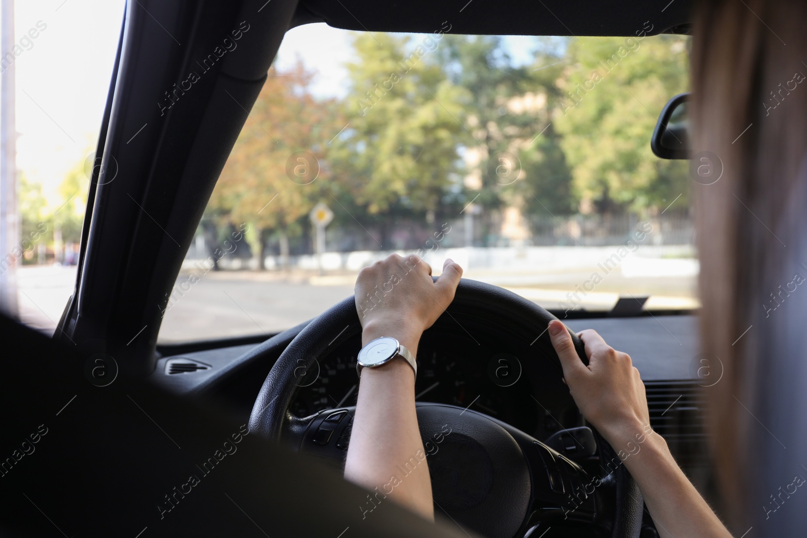 Photo of Woman holding steering wheel while driving car, closeup