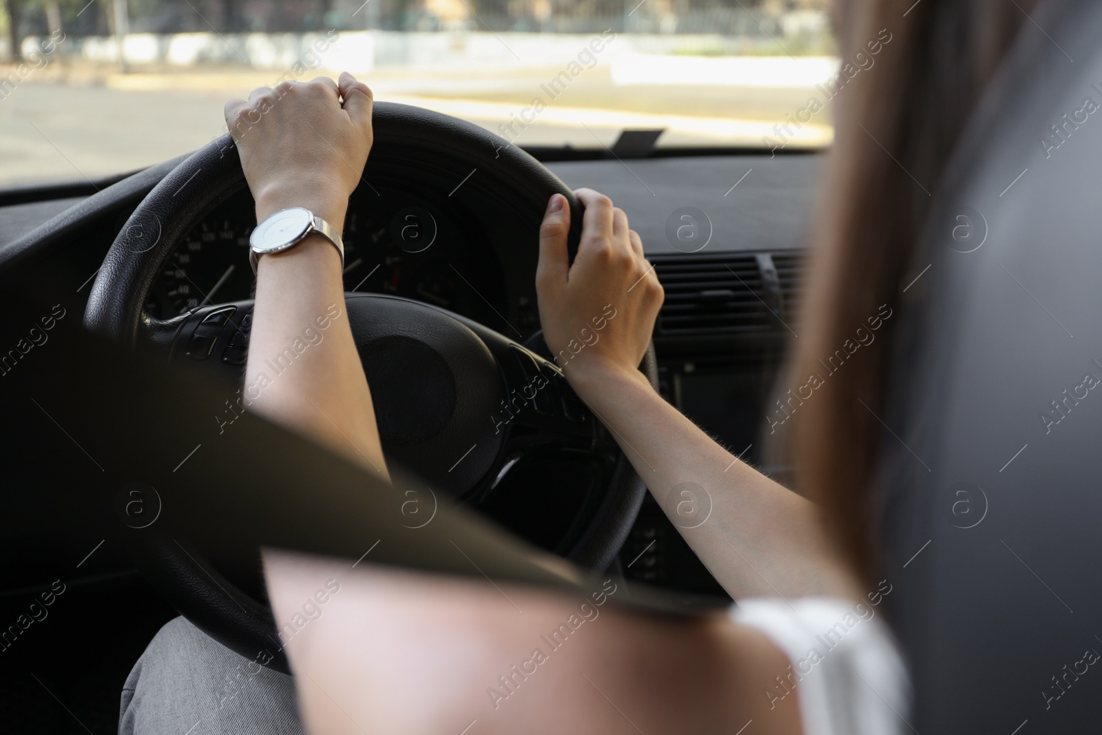 Photo of Woman holding steering wheel while driving car, closeup