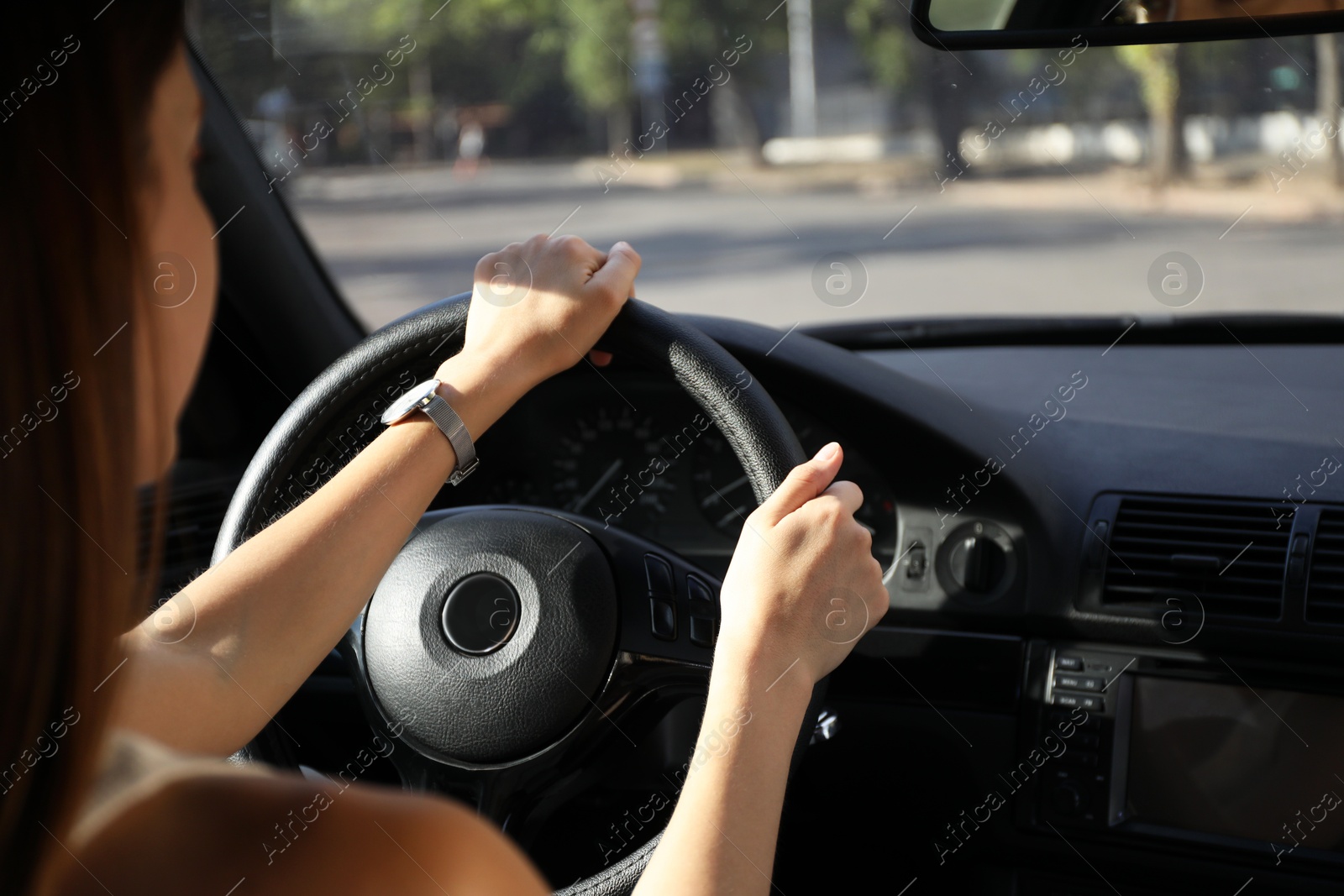 Photo of Woman holding steering wheel while driving car, closeup