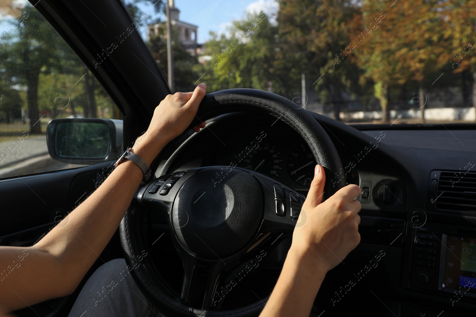 Photo of Woman holding steering wheel while driving car, closeup