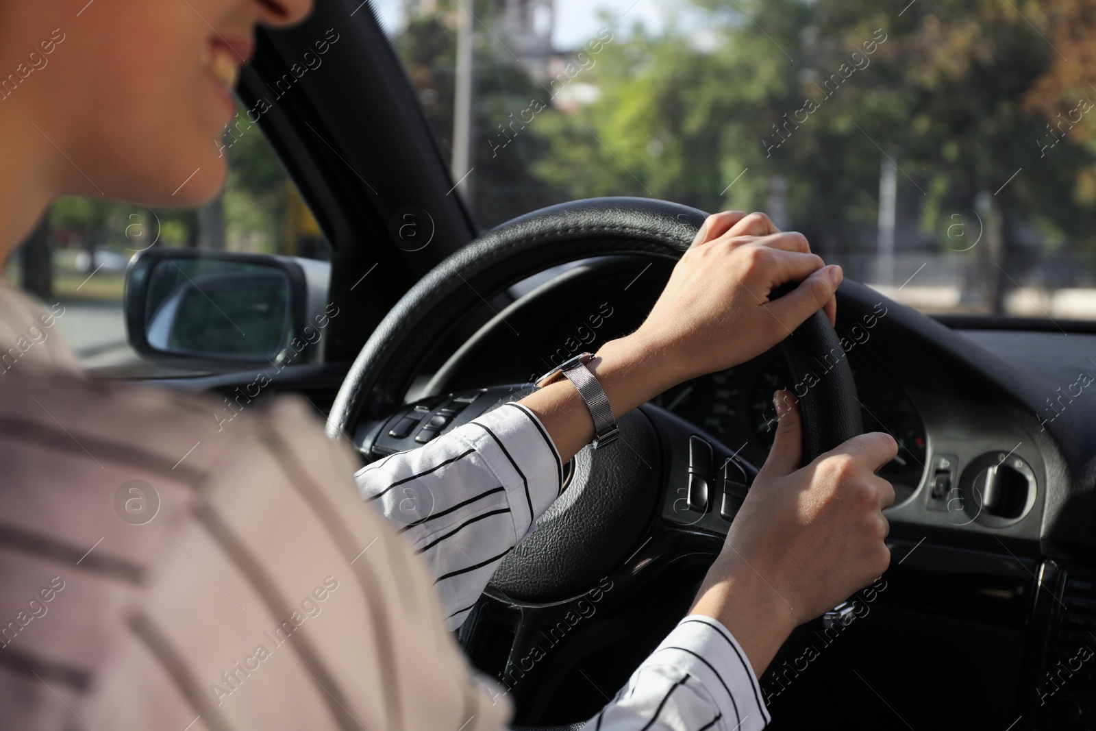 Photo of Woman holding steering wheel while driving car, closeup