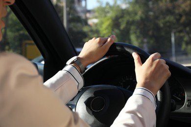 Photo of Woman holding steering wheel while driving car, closeup