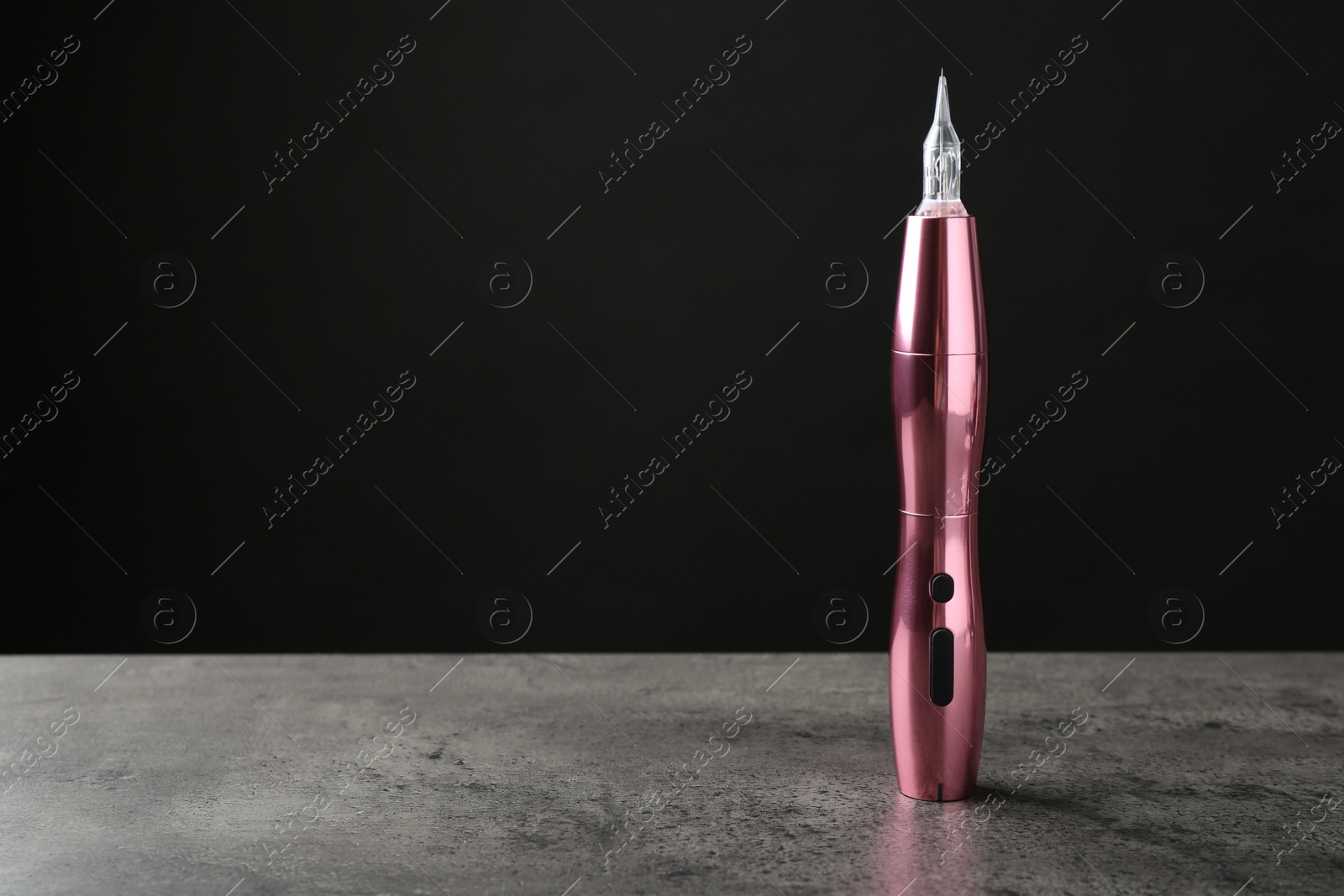 Photo of Professional permanent makeup machine on grey background. Space for text