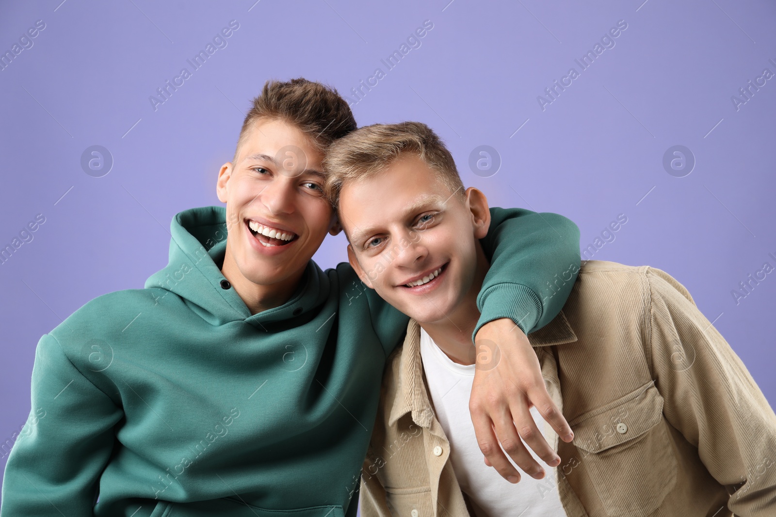 Photo of Portrait of happy brothers on violet background