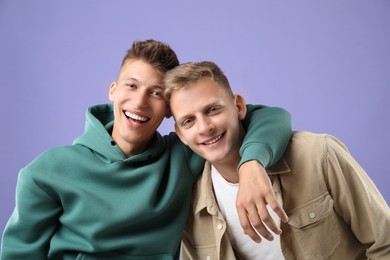 Photo of Portrait of happy brothers on violet background