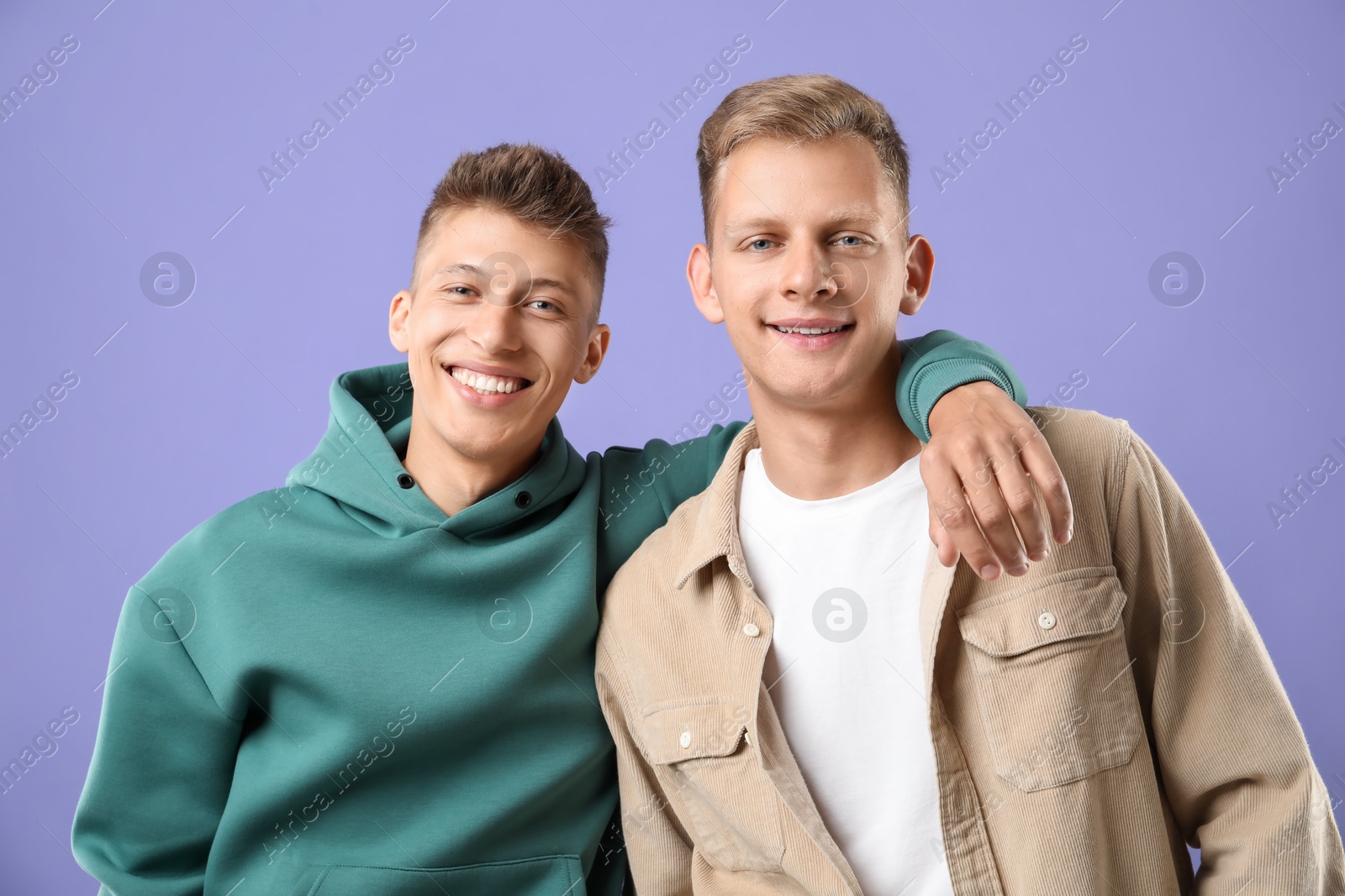 Photo of Portrait of happy brothers on violet background