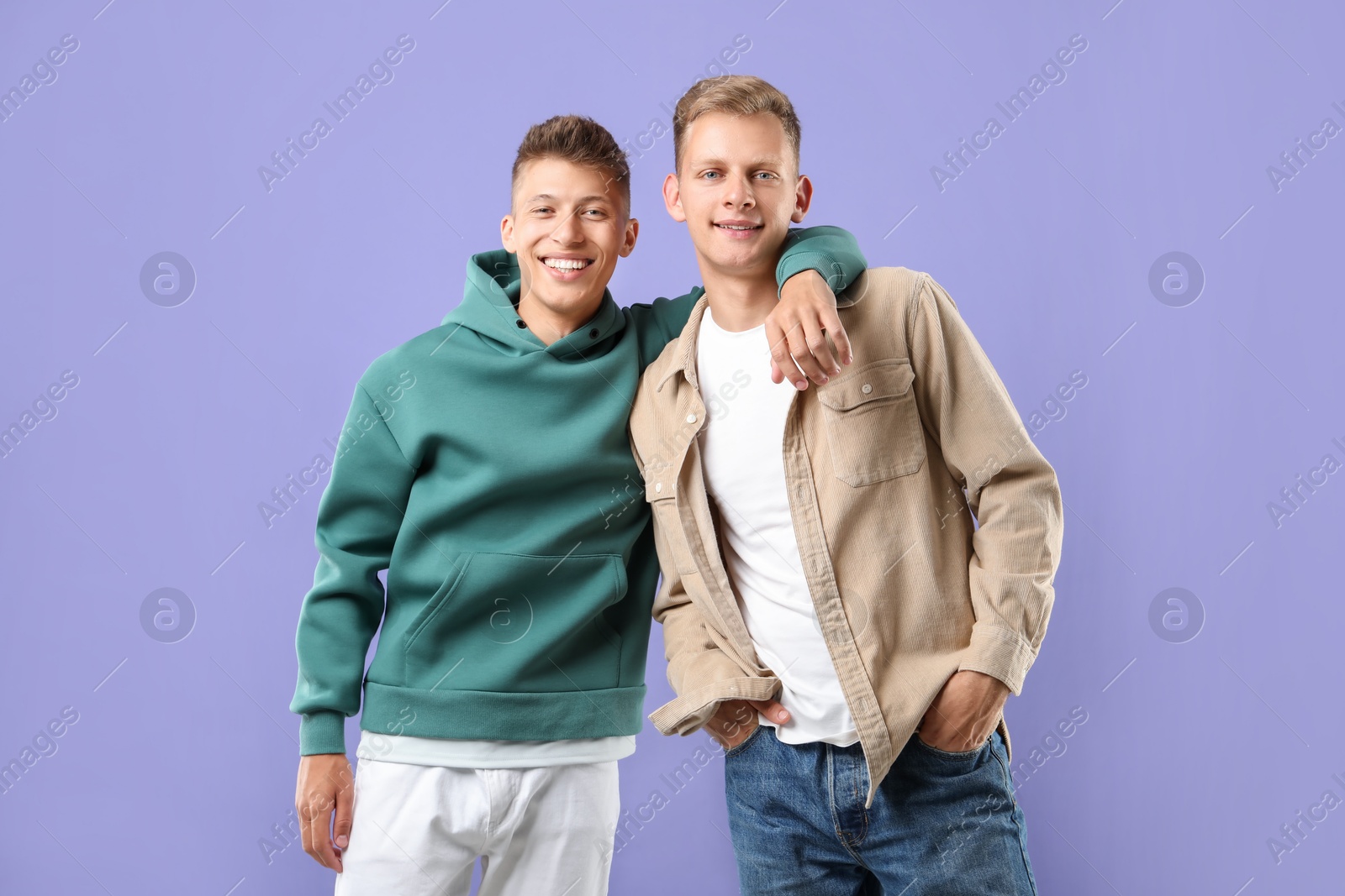 Photo of Portrait of happy brothers on violet background