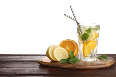 Photo of Glass of tasty refreshing drink with straws and fresh fruits on wooden table against white background