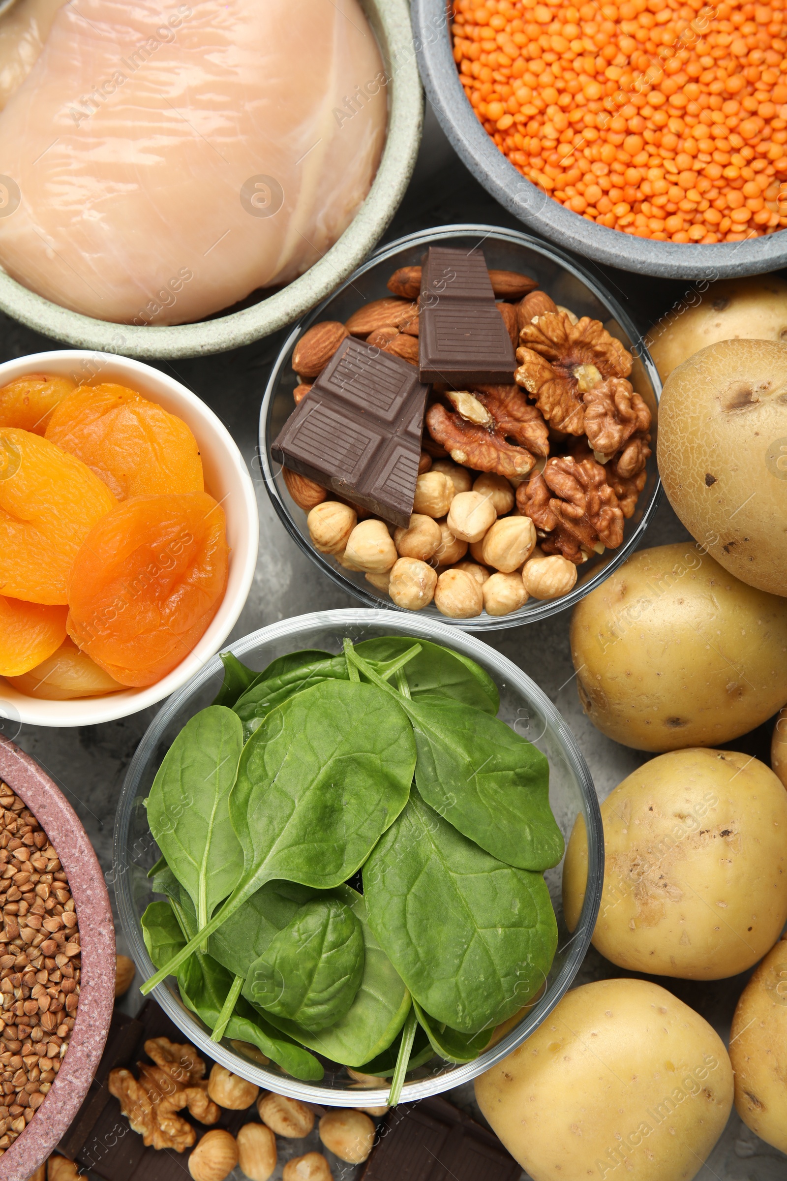 Photo of Different products rich in iron on grey table, top view. Diet plan for anemia