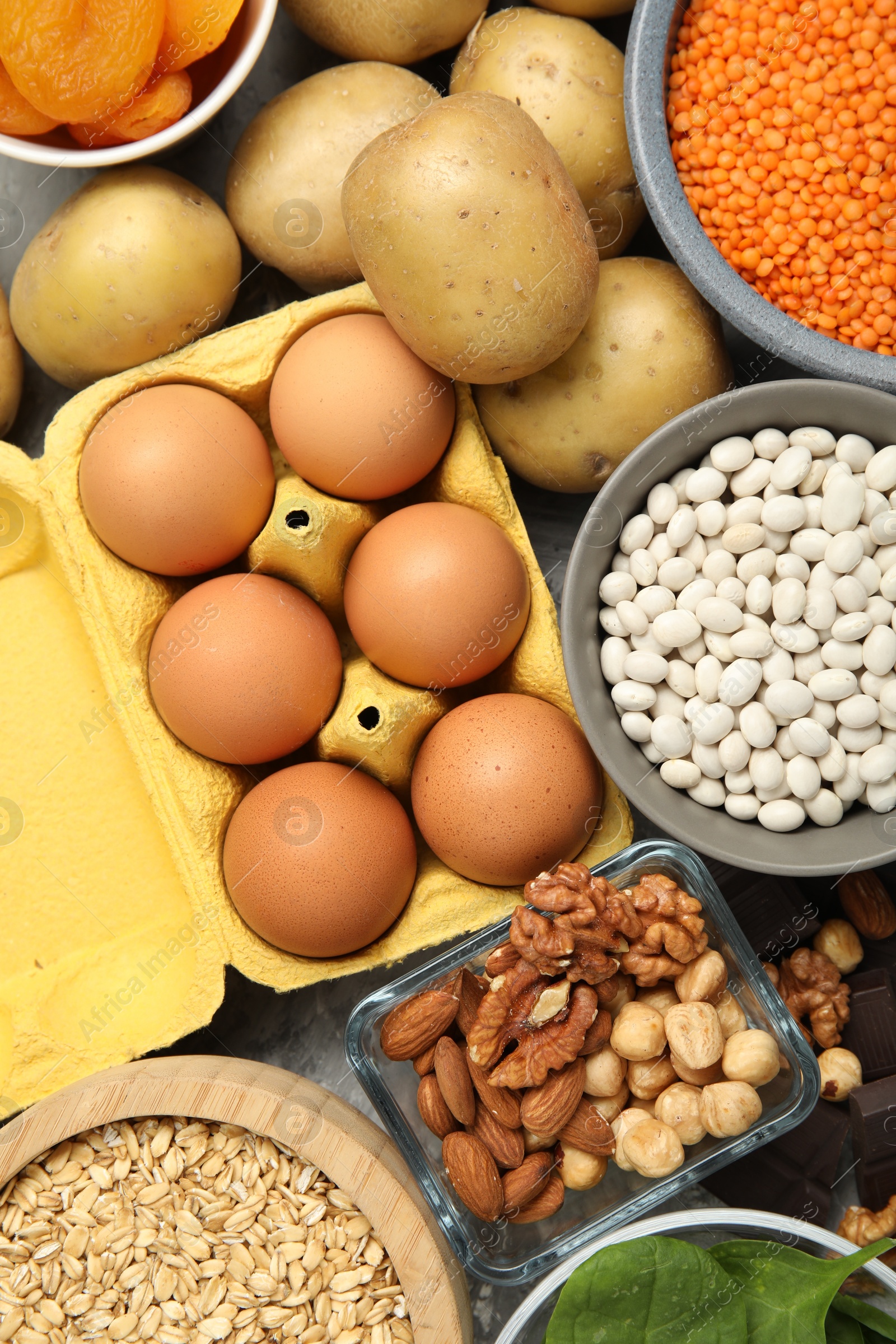 Photo of Different products rich in iron on grey table, top view. Diet plan for anemia