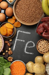 Photo of Diet plan for anemia. Different products rich in iron and slate board with Ferrum symbol on table, flat lay. Space for text