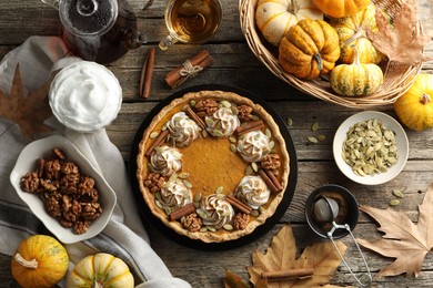 Flat lay composition with homemade pumpkin pie on wooden table