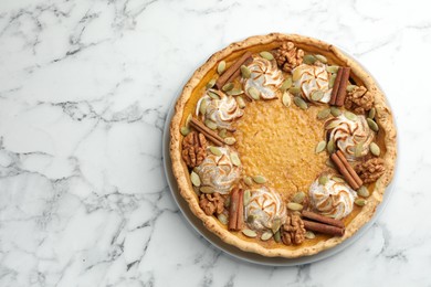 Photo of Tasty homemade pumpkin pie on white marble table, top view. Space for text