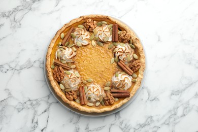 Tasty homemade pumpkin pie on white marble table, top view