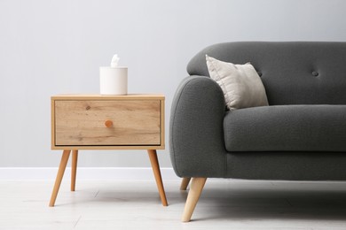 Photo of Comfortable sofa and table near grey wall in room