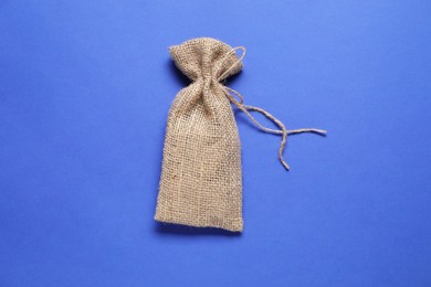 Photo of One burlap sack on blue background, top view