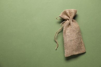 Photo of One burlap sack on olive background, top view. Space for text