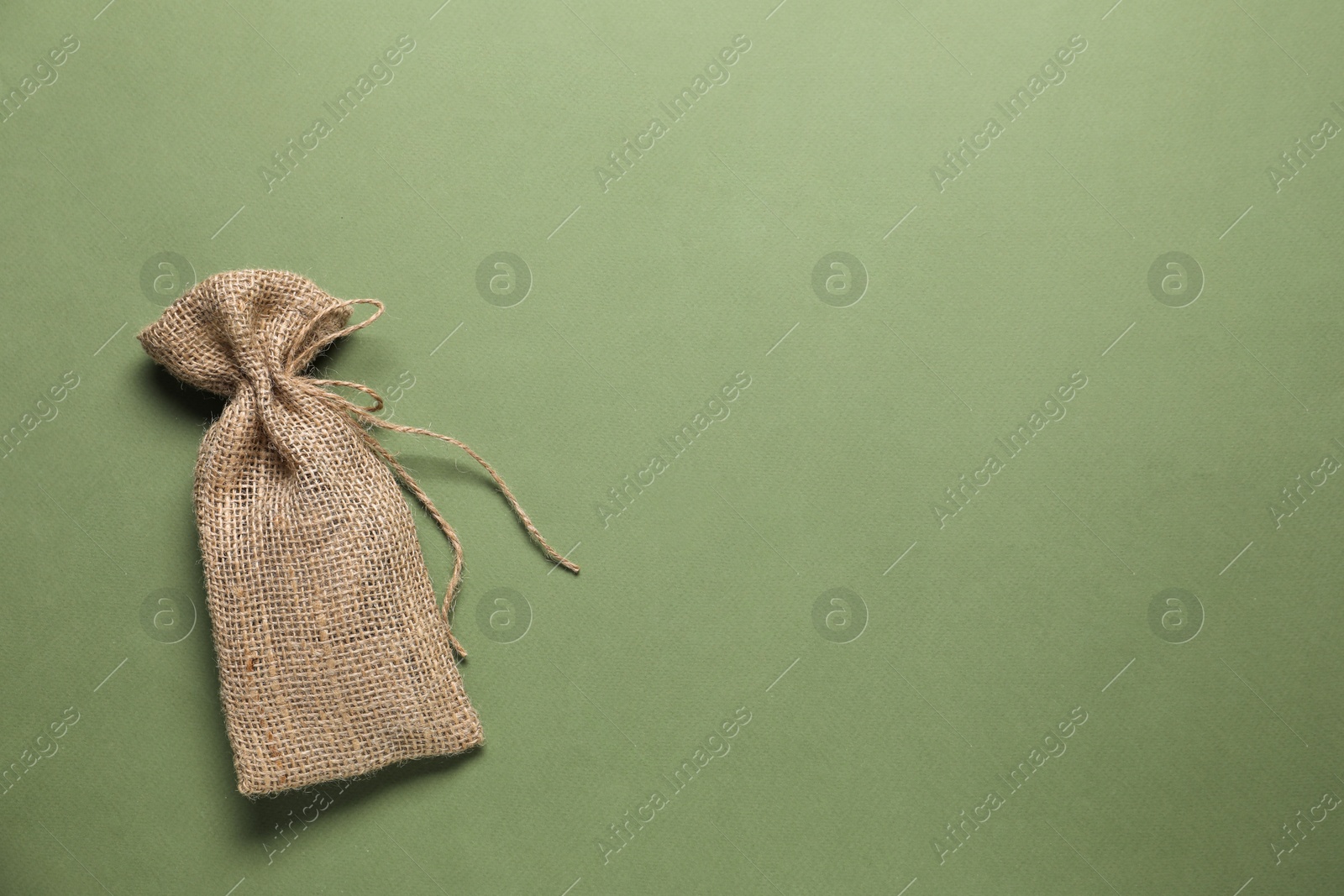 Photo of One burlap sack on olive background, top view. Space for text