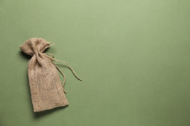 Photo of One burlap sack on olive background, top view. Space for text