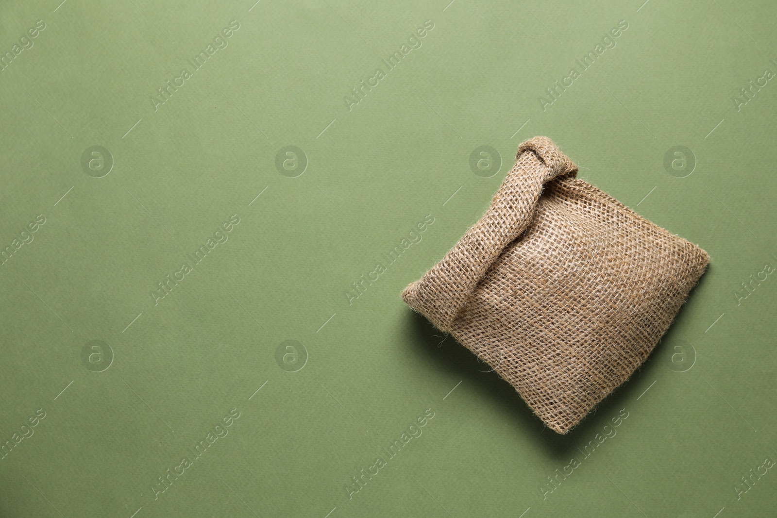 Photo of One burlap sack on olive background, top view. Space for text