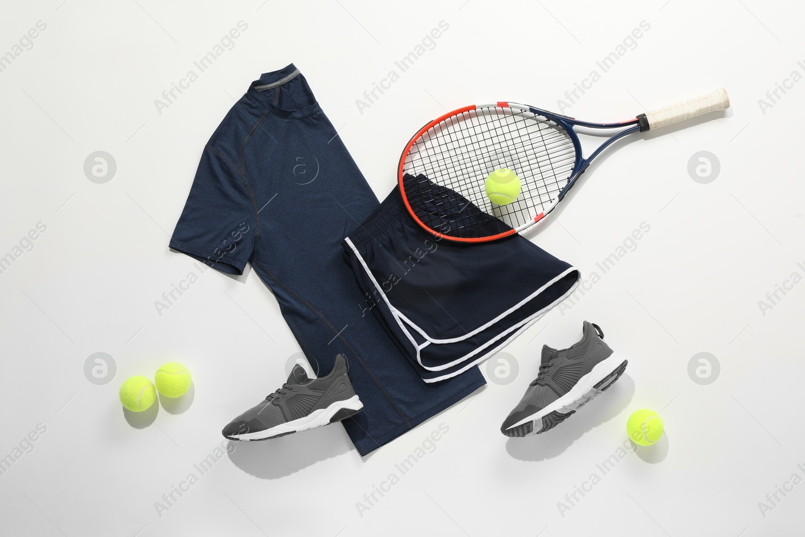 Photo of Tennis racket, balls, sneakers and sportswear on light background, flat lay