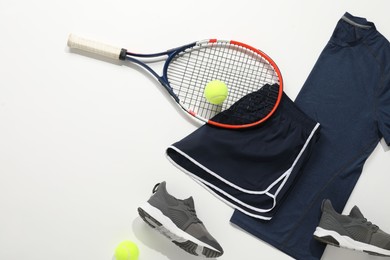 Photo of Tennis racket, balls, sneakers and sportswear on light background, flat lay. Space for text