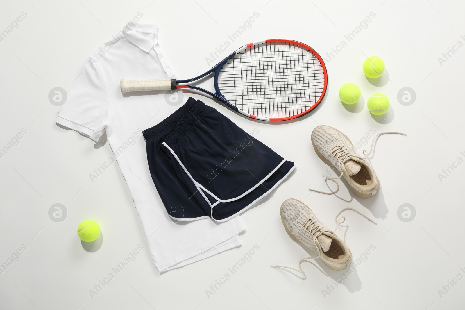 Photo of Tennis racket, balls, sneakers and sportswear on light background, flat lay