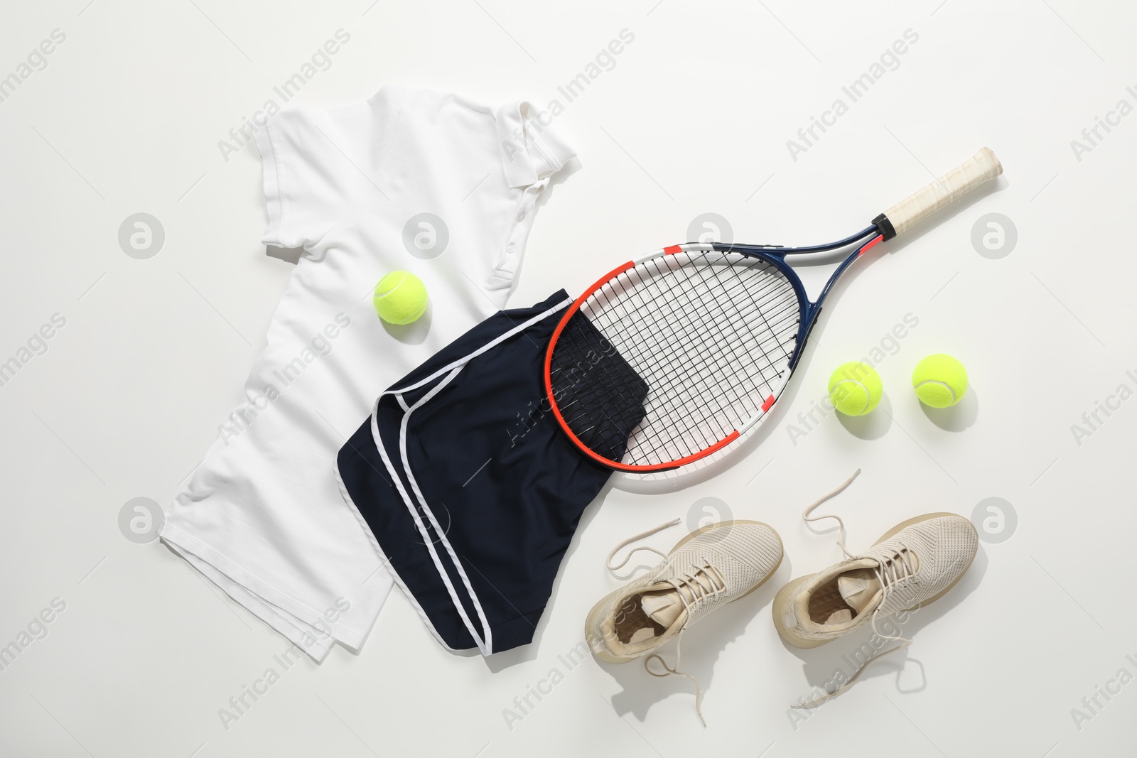 Photo of Tennis racket, balls, sneakers and sportswear on light background, flat lay