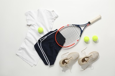 Photo of Tennis racket, balls, sneakers and sportswear on light background, flat lay