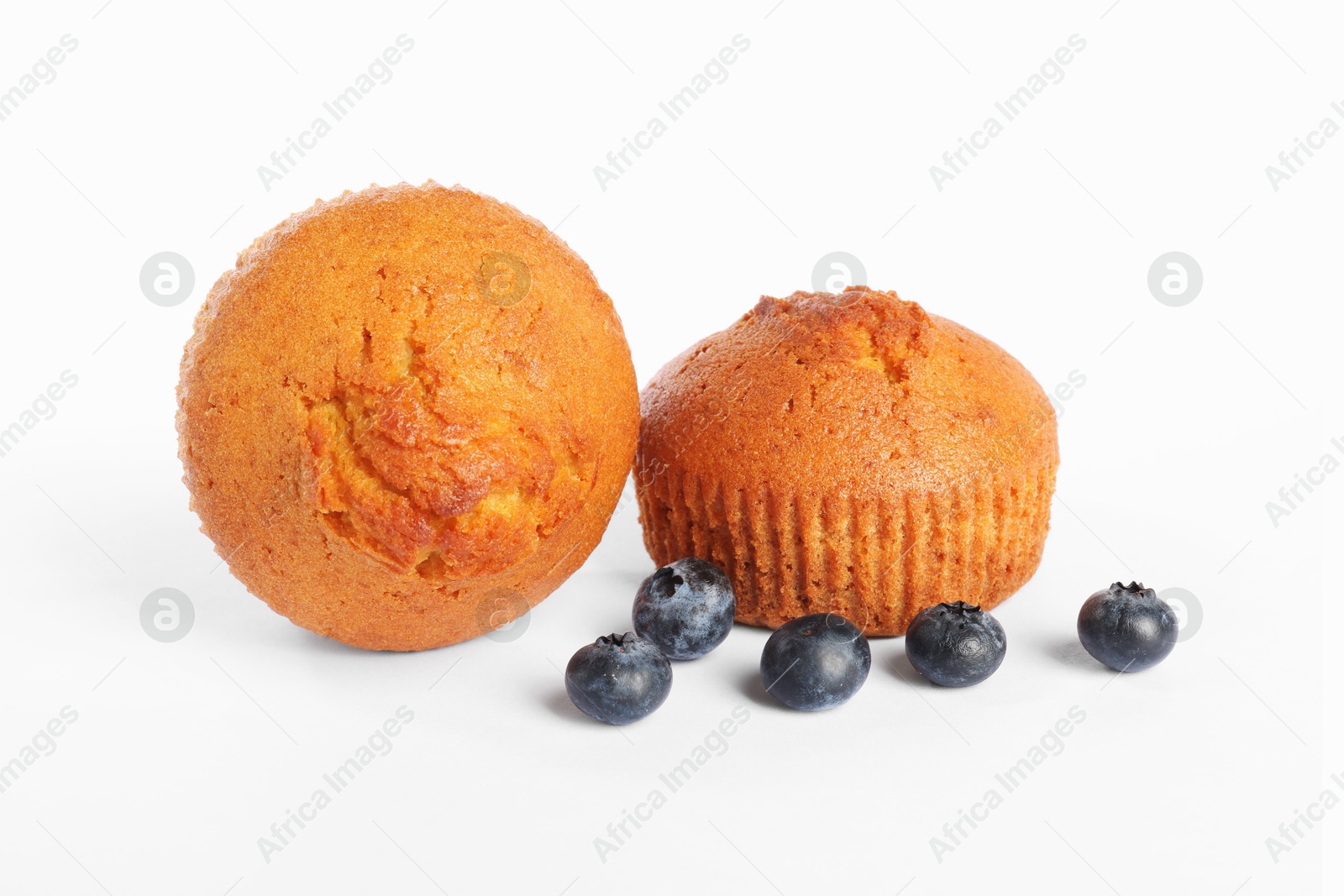 Photo of Delicious sweet muffins and blueberries isolated on white