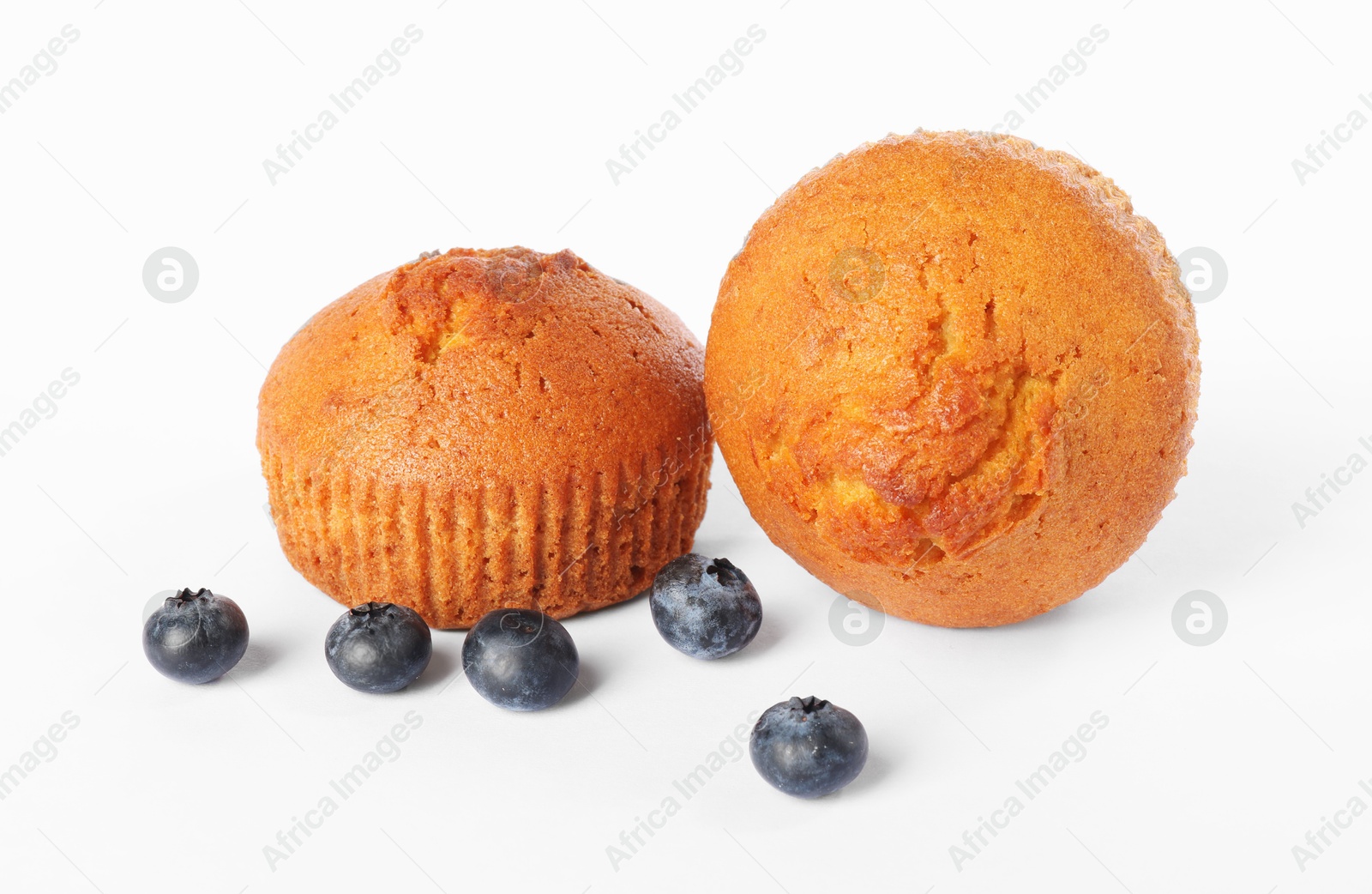 Photo of Delicious sweet muffins and blueberries isolated on white