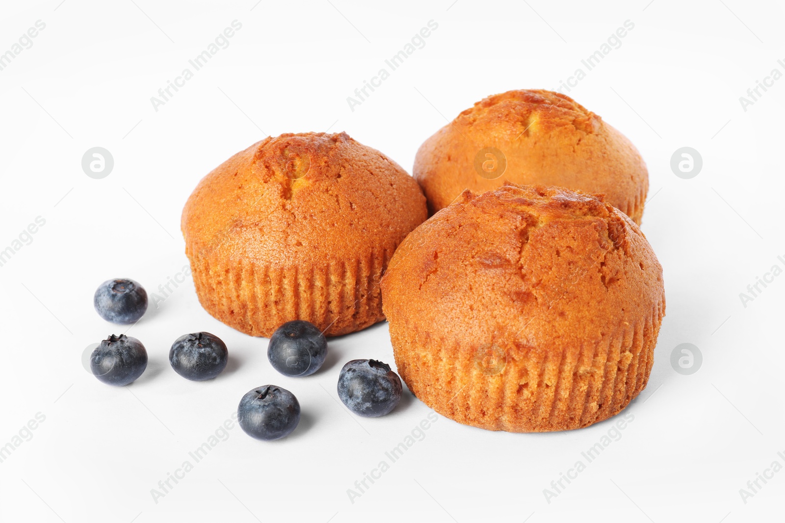 Photo of Delicious sweet muffins and blueberries isolated on white