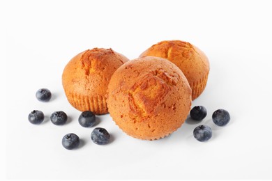 Photo of Delicious sweet muffins and blueberries isolated on white