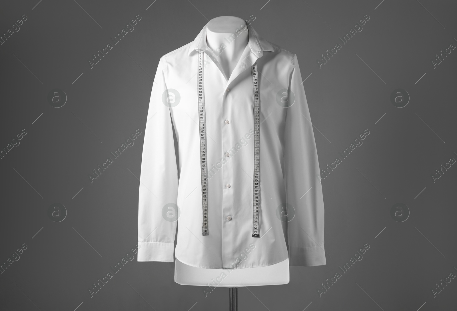 Photo of Male mannequin with white shirt and measuring tape on grey background