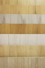 Photo of Many different samples of wooden flooring as background, closeup