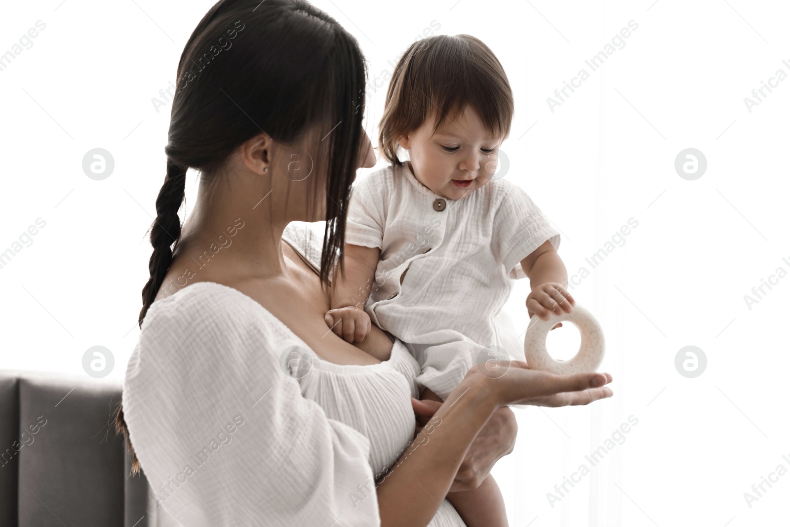 Photo of Beautiful young mother with her cute little baby indoors