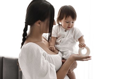 Beautiful young mother with her cute little baby indoors