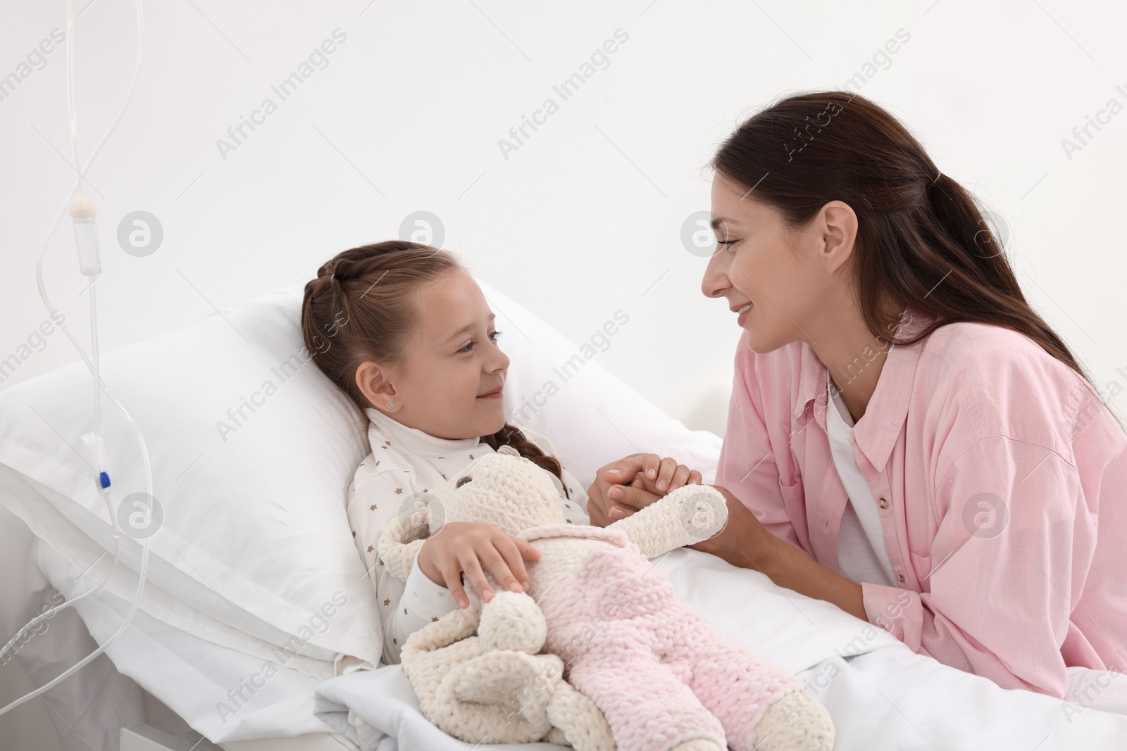 Photo of Mother and her little daughter on bed in hospital